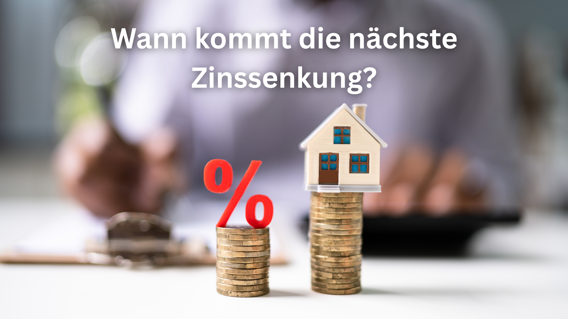 Wann kommt die nächste Zinssenkung - Münzstapel mit Haus und Prozentzeichen