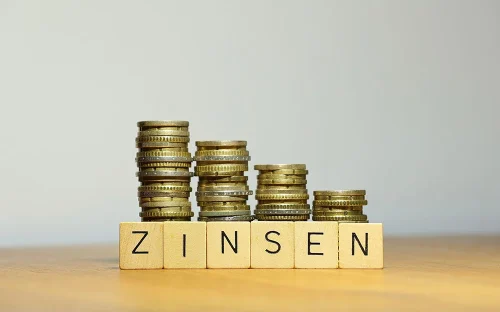 Bausparvertrag Zinsen - Münzstapel mit dem Wort ZINSEN